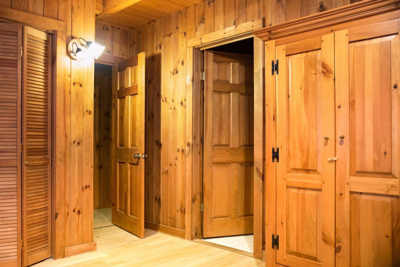 hallway with knotty pine on walls, ceiling, and doors