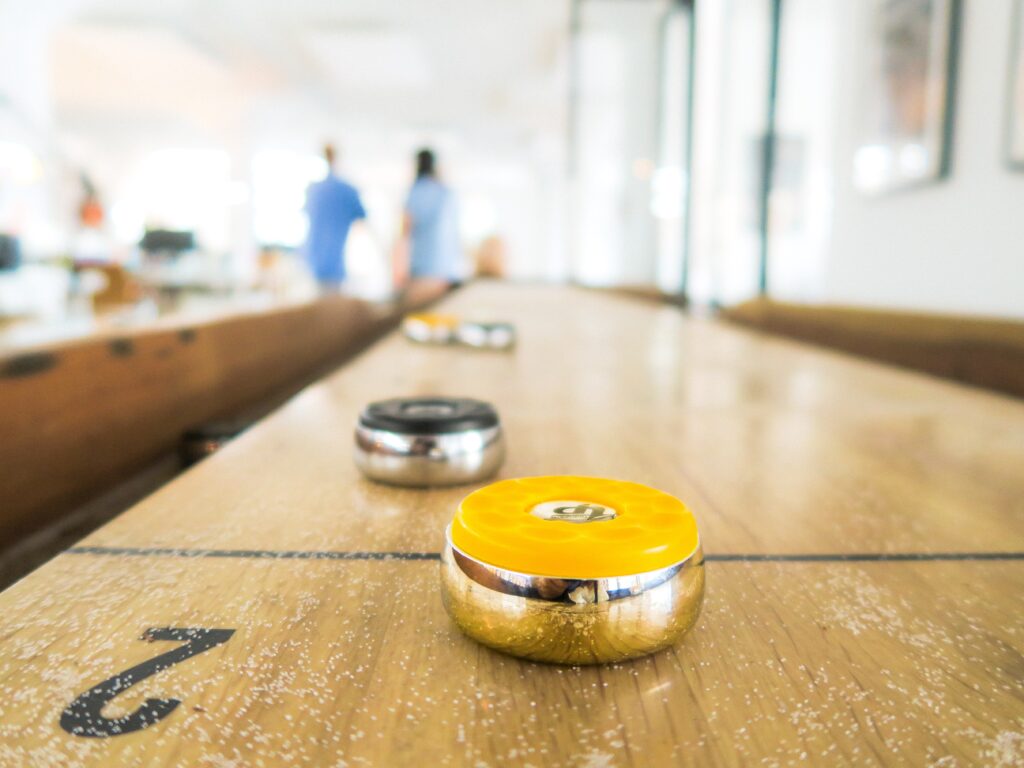close up of a shuffleboard table indoors with pucks