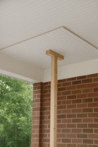DIYer using wooden T-brace to install beaded plywood ceiling panel