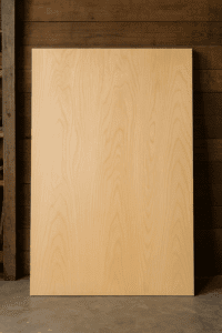 Full sheet of Sande plywood leaning against a workshop wall, showing light color and fine grain