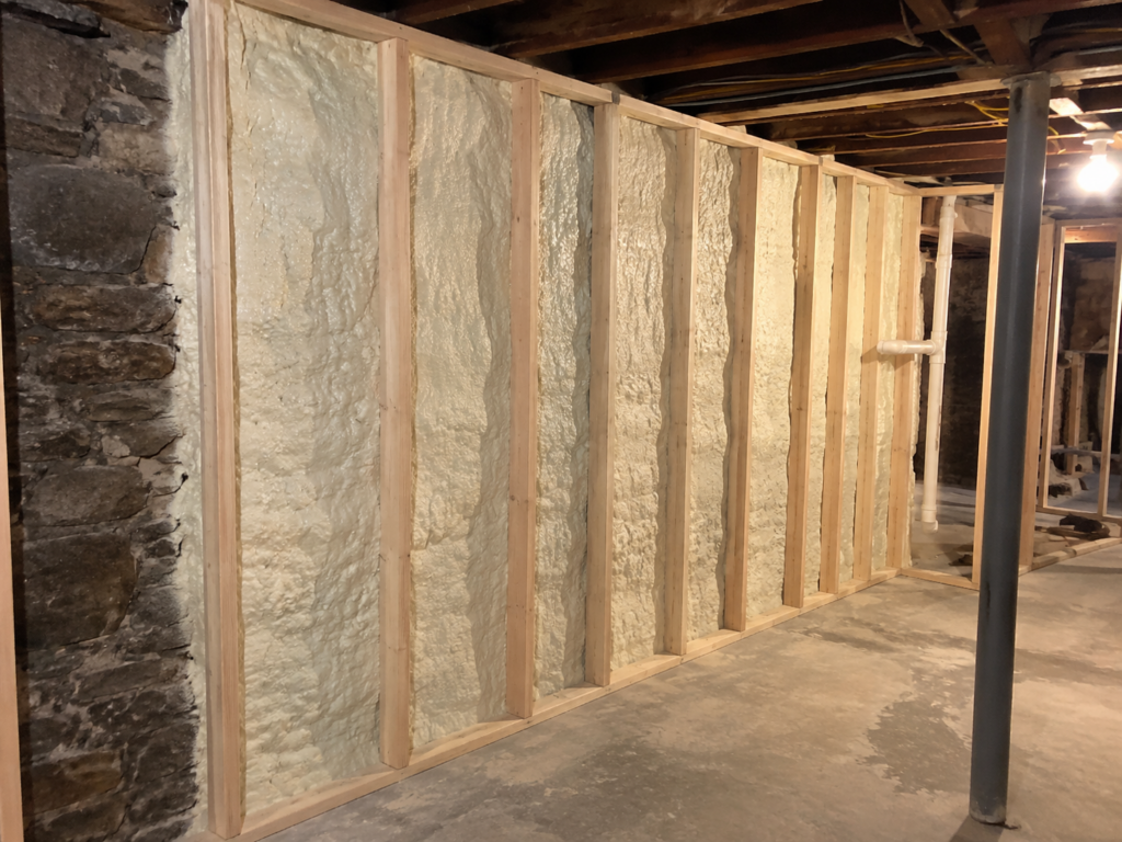 Closed-cell spray foam installed on an irregular basement foundation wall