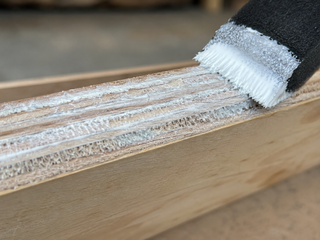 Close-up of primer soaking into the raw edge layers of exterior plywood