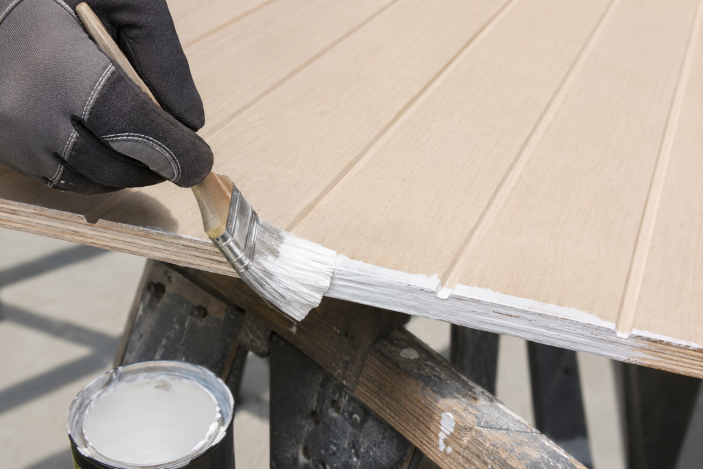 Applying exterior primer to the cut edge of a T1-11 plywood siding panel