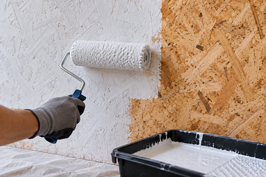 How to paint OSB using a roller to apply white stain-blocking primer over an unfinished OSB wall before painting.
